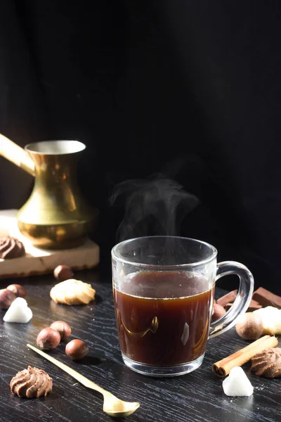 Hot coffee is poured into a transparent Cup from above. The hot steam coming from the mug