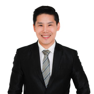 Genç ve yakışıklı gülümseme ve dost canlısı yüz işi Asyalı siyah takım elbiseli, kırmızı kravatlı, kendine güvenen ve gri arka planda başarılı bir jest yapan kameraya bakıyor..