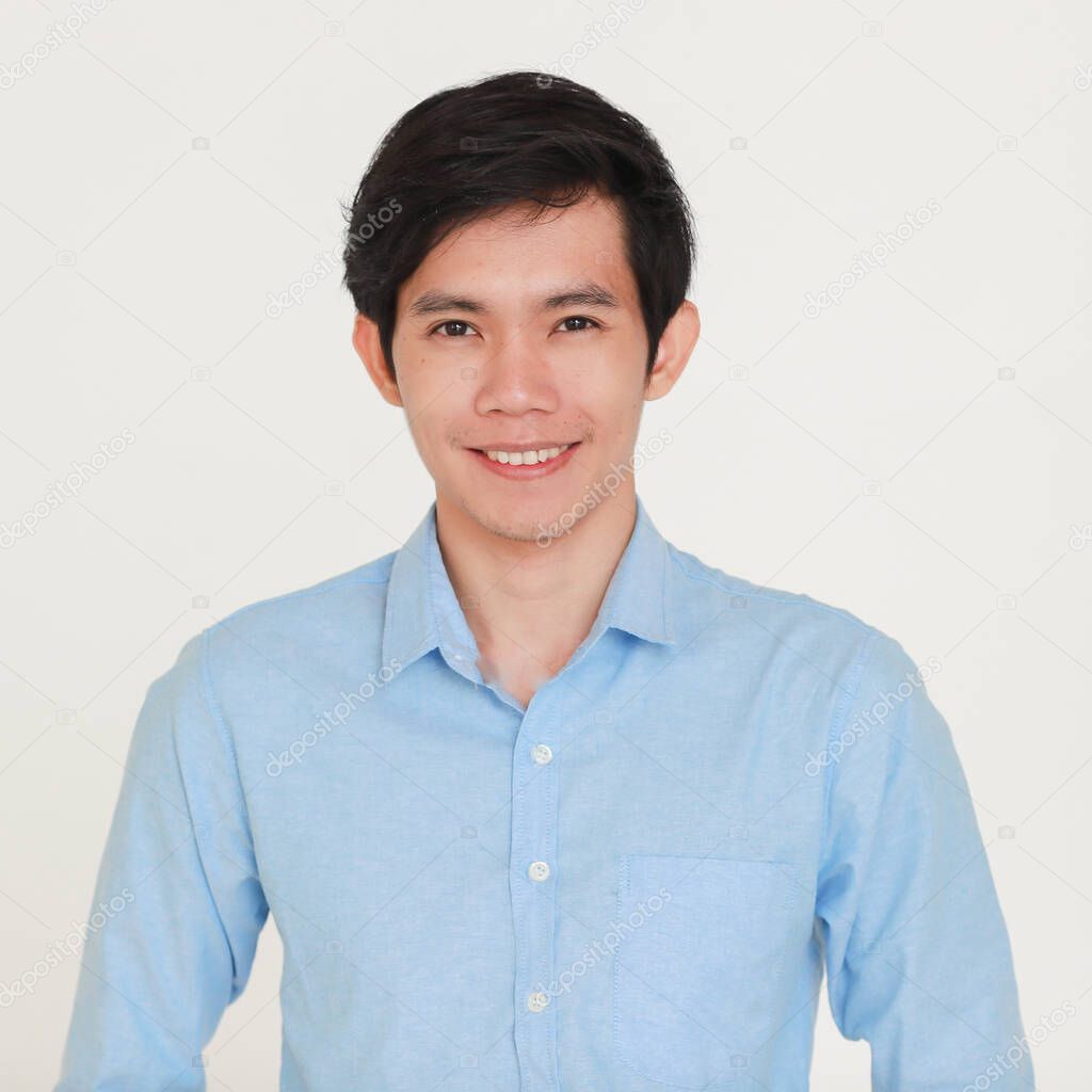 Young and handsome smiley and friendly face Asian man in casual business shirt looking at camera with self-confident and success gesture on grey background.