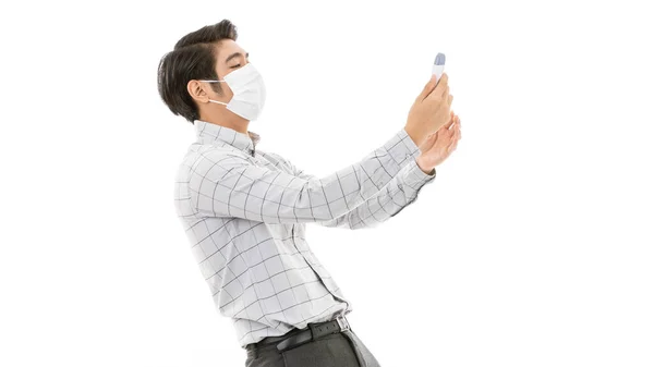 白地に隔離された医療用インフルエンザ保護マスクを身に着けているカジュアルビジネス布の若いとハンサムな男は興奮し 強調し デジタル温度計から結果を読んだ後怖がって感じる — ストック写真