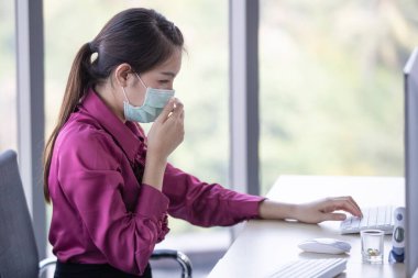 Yüzüne hijyen koruyucu maske takan bir iş kadını ve kendini hasta hissediyor. Uyarı yaptı ve elini yüzünü örtmek için kullandı. İş yerinde Corona virüsü yayılması ve riski 2019.