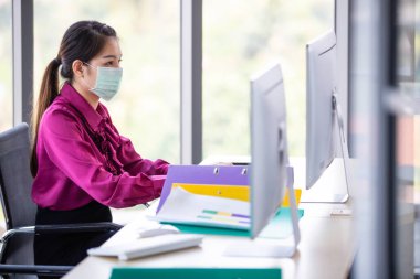 Ofis ve işyerindeki tehlikeli kirli hava ve virüs hastalıklarından korunmak için çalışan ve yüzüne cerrahi maske takan bir kadın. Hayatım, günlük hayatta sağlıkla ilgilendiğin için..