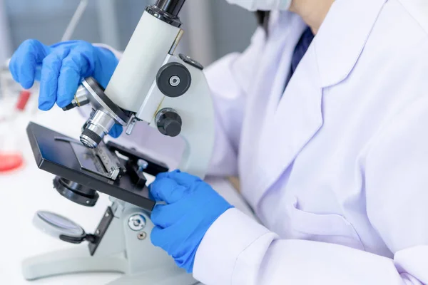 研究室で働く女性科学者の研究者は 顕微鏡を使用して実験室機器でのテストの解決策を見つける 新しい知識のための医療ビジネスに従事する人々のための概念 — ストック写真