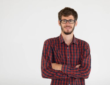 Gözlüklü, gri arka planda duran, kendine güvenen ve kameraya mutlu bakan genç ve yakışıklı bir adamın portresi. Kendine güveni olan beyaz adamın yarı vücut fotoğrafı..