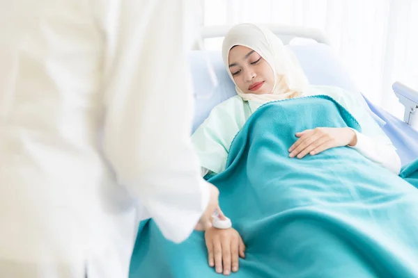 ヒジャーブを身に着けているイスラム教徒の女性患者は 病院でベッドの上に横たわり 注射器と針を見てください 彼女の顔は笑顔で大胆不敵です ヘルスケアビジネスサービスの考え方 — ストック写真