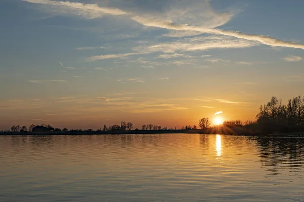 Die Untergehende Sonne Erhellt Ein Einziges Kondensstreifen Über Dem See — Stockfoto