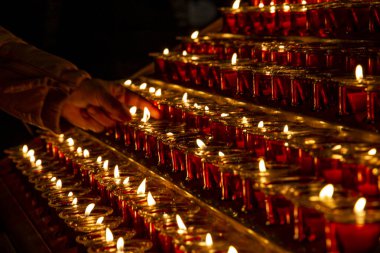 Katedraldeki eski bir avizede mum yakmak.