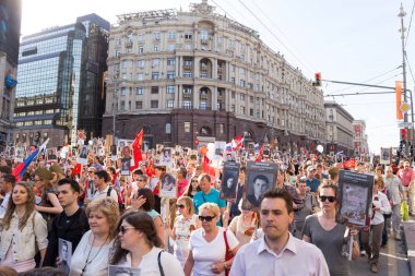  Zafer Bayramı - binlerce bayrakları ve iki Dünya Savaşı içinde savaşan sevdiklerini anısına portre ile Kızıl Meydan doğru Tverskaya Caddesi boyunca yürüyen insan ölümsüz alay alay 