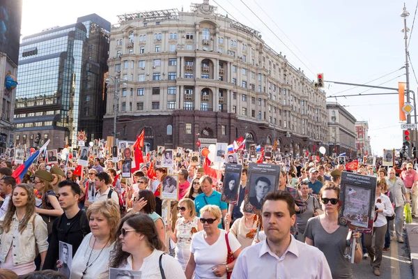 Immortal Regiment procession in Victory Day - thousands of people marching along Tverskaya Street toward the Red Square with flags and portraits in commemoration of their loved ones who fought in World War Two — Stock Photo, Image
