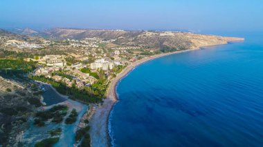 Hava kuş bakışı, Pissouri bay, Limasol ve Baf Kıbrıs arasında bir köy yerleşmesi. Panoramik manzaralı sahil, beach hotel, resort, tepeler, düz ve yukarıdan bina gelişmeler.