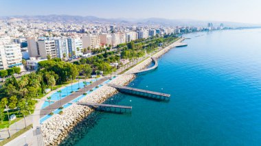 Kıbrıs Limasol sahil kent merkezinde hava görünümünü Molos Promenade Park. Kuş bakışı jetties, sahil yürüyüş yolu, palmiye ağaçları, Akdeniz, iskeleler, kayalar, şehir manzarası ve port yukarıdan.
