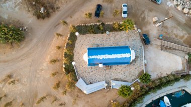 Günbatımının ve tarihi işaretlerin hava manzarası yukarıdan Agia Triada, Protaras, Famagusta ve Kıbrıs 'ın modern kemer şapelini yıkadı. Gündoğumunda Ammochostos bölgesindeki sahil kenarındaki Ayia Trias mavi körfez kilisesine kuş bakışı turistik manzara.