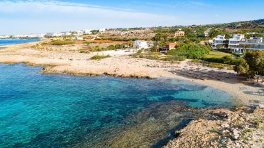 Ammos tou Kambouri plajı, Ayia Napa, Cavo Greco, Famagusta, Kıbrıs 'ın kuş bakışı görüntüsü. Yaz tatillerinde Agia Napa 'da altın kumu, güneşliği ve deniz restoranı olan kayalık plaj manzarası..