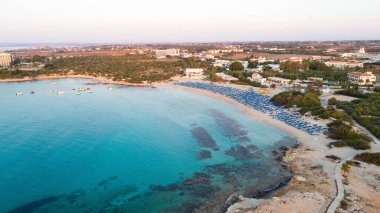 Landa plajı, Ayia Napa, Famagusta, Kıbrıs 'ın havadan kuş bakışı görüntüsü. Gündoğumunda turistlerin uğrak yeri altın kumsaldır. Güneş yatakları, Makronissos ve Agia Napa arasında deniz restoranları vardır. Yaz tatillerinde yukarıdan..