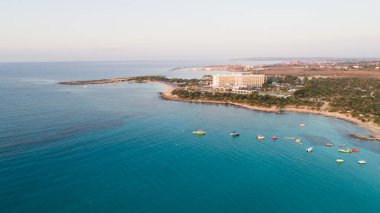 Landa plajı, Ayia Napa, Famagusta, Kıbrıs 'ın havadan kuş bakışı görüntüsü. Gündoğumunda turistlerin uğrak yeri altın kumsaldır. Güneş yatakları, Makronissos ve Agia Napa arasında deniz restoranları vardır. Yaz tatillerinde yukarıdan..