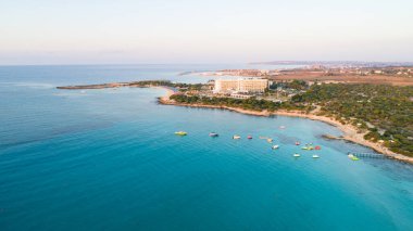 Landa plajı, Ayia Napa, Famagusta, Kıbrıs 'ın havadan kuş bakışı görüntüsü. Gündoğumunda turistlerin uğrak yeri altın kumsaldır. Güneş yatakları, Makronissos ve Agia Napa arasında deniz restoranları vardır. Yaz tatillerinde yukarıdan..