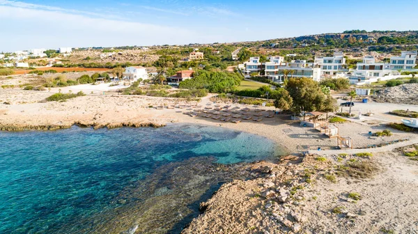 Ammos tou Kambouri plajı, Ayia Napa, Cavo Greco, Famagusta, Kıbrıs 'ın kuş bakışı görüntüsü. Yaz tatillerinde Agia Napa 'da altın kumu, güneşliği ve deniz restoranı olan kayalık plaj manzarası..