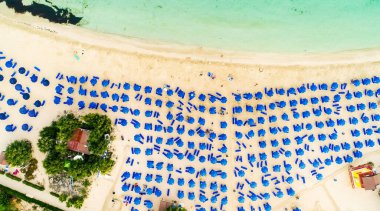 Ünlü Makronissos sahil şeridi Ayia Napa, Famagusta, Kıbrıs 'ın havadan kuş bakışı manzarası. Günbatımında Agia Napa 'da altın kum, güneşlik, deniz restoranları ve yaz tatilleri ile turistik mekan Makronisos Körfezi..