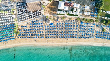 Pantachou 'nun havadan kuş bakışı görüntüsü - Limanaki kumlu plajı (Kaliva), Ayia Napa, Famagusta, Kıbrıs. Yaz tatillerinde Agia Napa 'da altın kumları, güneş şemsiyeleri, deniz yatakları, bar restoranları olan turistik bir körfez..