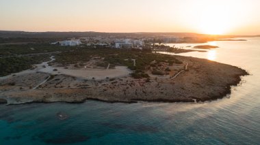 Landa plajı, Ayia Napa, Famagusta, Kıbrıs 'ın havadan kuş bakışı görüntüsü. Gündoğumunda turistlerin uğrak yeri altın kumsaldır. Güneş yatakları, Makronissos ve Agia Napa arasında deniz restoranları vardır. Yaz tatillerinde yukarıdan..