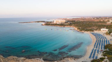 Landa plajı, Ayia Napa, Famagusta, Kıbrıs 'ın havadan kuş bakışı görüntüsü. Gündoğumunda turistlerin uğrak yeri altın kumsaldır. Güneş yatakları, Makronissos ve Agia Napa arasında deniz restoranları vardır. Yaz tatillerinde yukarıdan..