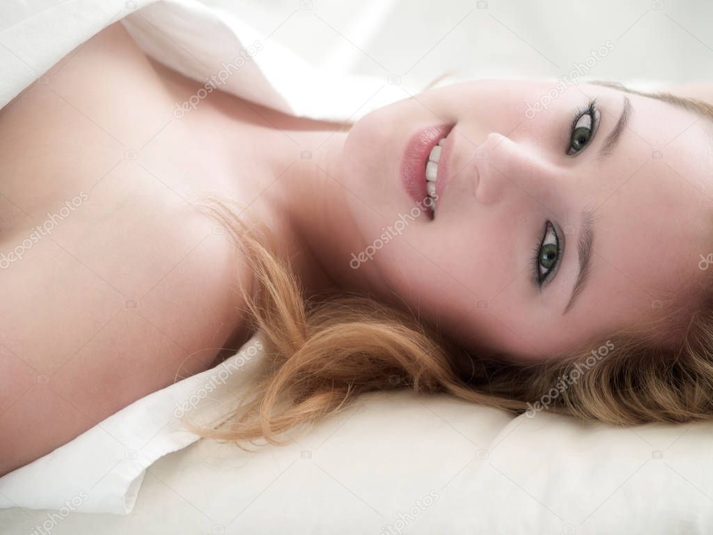 pretty young blonde woman lying in bed