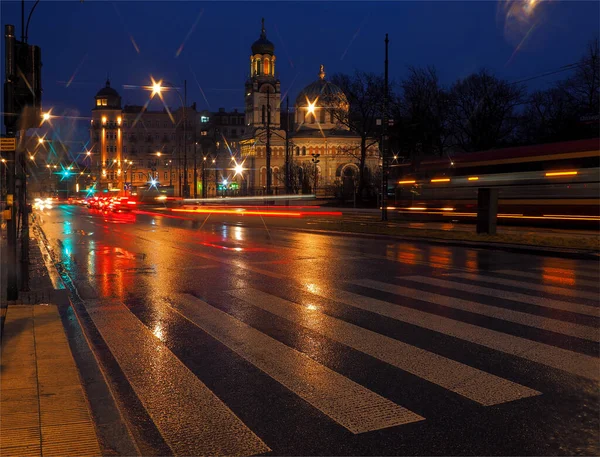 Dark wet city.   Lodz, Poland - March 06, 2020  Blurry evening traffic during rainfall in the center of Lodz.