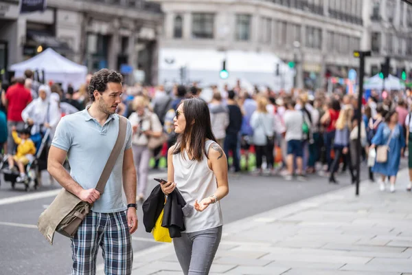 London, Storbritannien, 14 juli 2019. Samtal mellan två personer i överfulla Street London. Utvalt fokus — Stockfoto