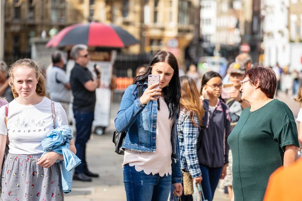 Cambridge, Storbritannien, 1 augusti 2019. Turister gå ner och ta bilder på gatan i Cambridge på en hektisk solig dag framför Kings College — Stockfoto