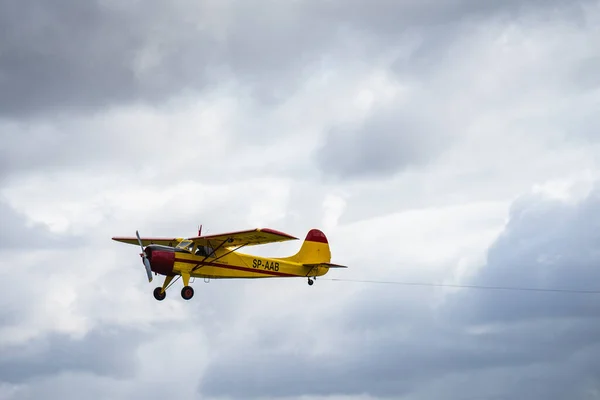 Kleine eenmotorige vliegtuig vliegen in de Engels bewolkte hemel — Stockfoto