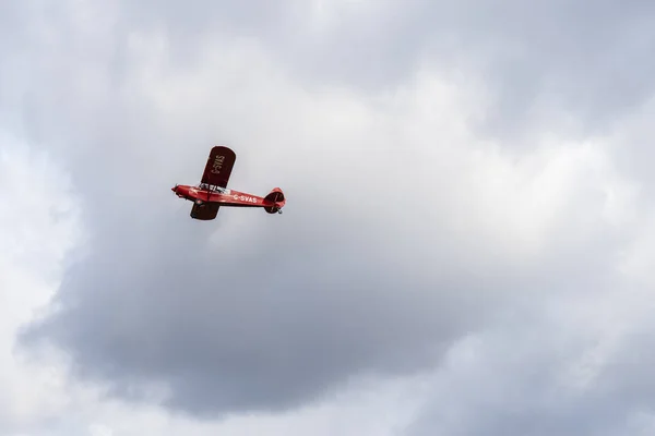 Kleine eenmotorige vliegtuig vliegen in de Engels bewolkte hemel — Stockfoto