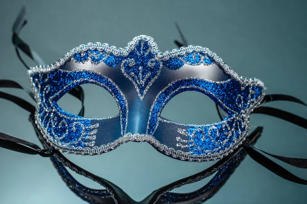 stock image The Colombina, blue carnival or masquerade mask on black mirror background