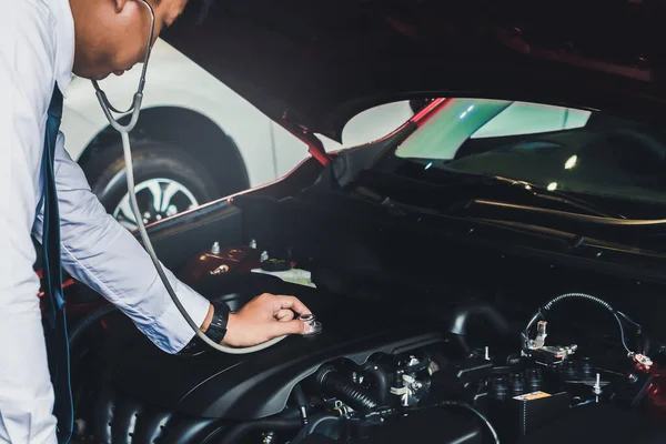 Asian man holding stethoscope car inspection Rubber tires car.Cl — Stock Photo, Image