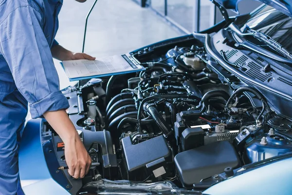 Asian Man mechanik kontroli pisanie notatki na schowku.Blue samochód — Zdjęcie stockowe