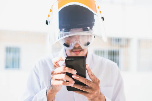 携帯電話を使用して保護マスクとヘルメットの男 — ストック写真