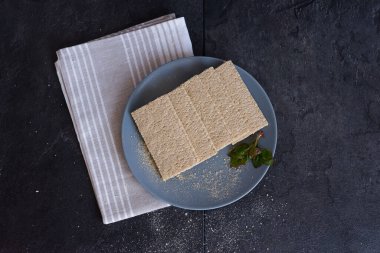 Sağlıklı yiyecekler. Siyah arka planda gri bir tabakta taze yapraklı çıtır ekmek ve hafif pamuklu bez. Diyet ve sağlıklı beslenme. Kilo verme ve sağlıklı bir yaşam tarzı..