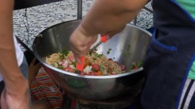 Yemek pazarında salata ve makarna hazırlayan kadını yakından çek.