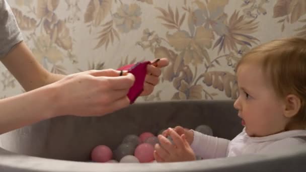 Das süße kleine Mädchen zeigt, dass es während der Quarantäne keine Gesichtsmaske ausprobieren will — Stockvideo