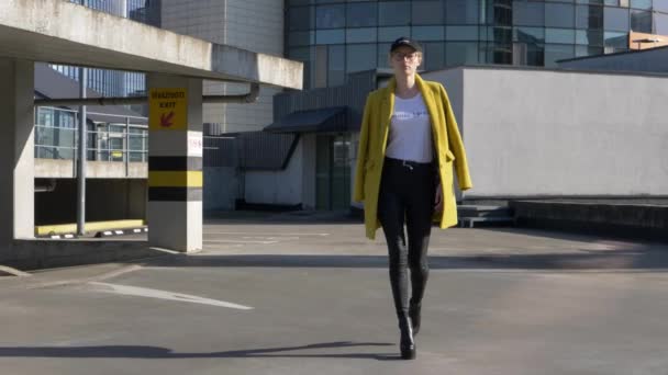 Zelfverzekerde supermodel met hoge hakken wandelingen op het dak van de parkeerplaats, draagt feministische zingt — Stockvideo