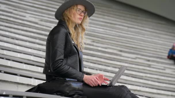 Jovem mulher bonita tenta encontrar uma nova ideia para seu roteiro, trabalhando com laptop, roupas de cor preta — Vídeo de Stock