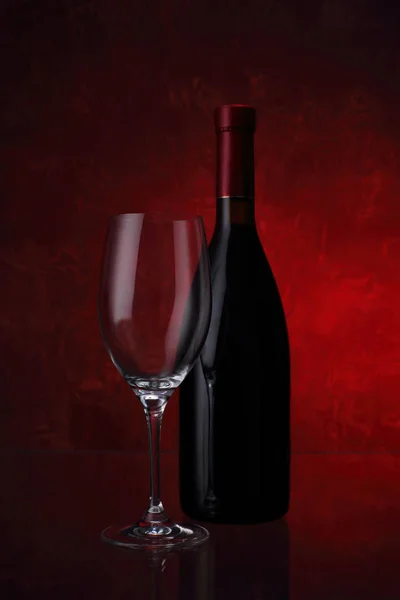 Borospohár és palack vörösbor — Stock Fotó