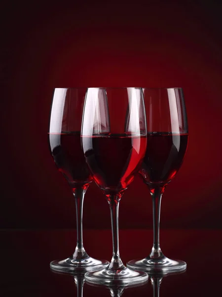 Tres copas de vino con un poco de vino en rojo — Foto de Stock