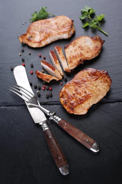 Grilled beef  steaks with fork and knife on slate stone — Stock Photo, Image