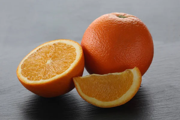 Oranges sur planche à découper noire — Photo