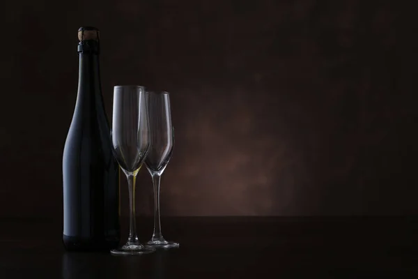 Bottiglia di champagne e due bicchieri su sfondo marrone — Foto Stock