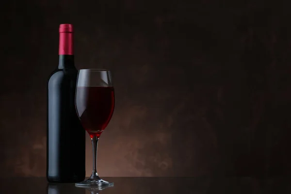 Bottiglia Vino Bicchiere Vino Rosso Sfondo Marrone Scuro — Foto Stock