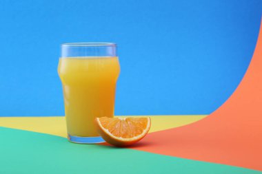 Parlak arkaplanda bir bardak portakal suyu ve meyve.