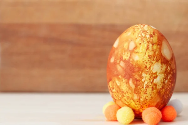 Very beautiful Colored orange egg on a light background on a stand with place for text. — Stock Photo, Image