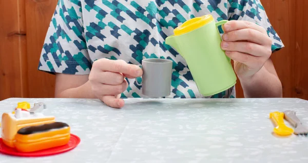 Çocuk oyuncaklarla oynar, çay döker, çocuklar evde karantina yapar, konsept oyunu, eğitim.