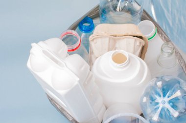 Plastik, ayıklanmış çöp, arka planda beyaz şişeler, kağıt, bardak gibi bir poşetin içinde yatıyor. Ekoloji konsepti, çöpleri ayırmak .